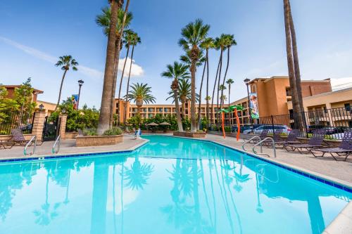 a swimming pool at a resort with palm trees and buildings at Grand Legacy At The Park in Anaheim