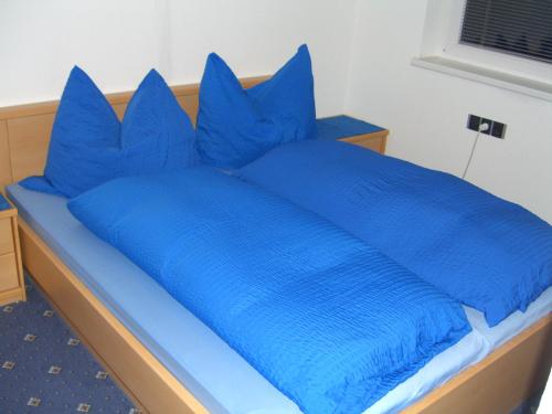 a blue bed with blue pillows on top of it at Appartement Granbichler Siegfried in Längenfeld