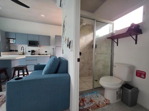 a bathroom with a blue couch and a bathroom with a shower at The Palm at Life's a Beach in Uvita