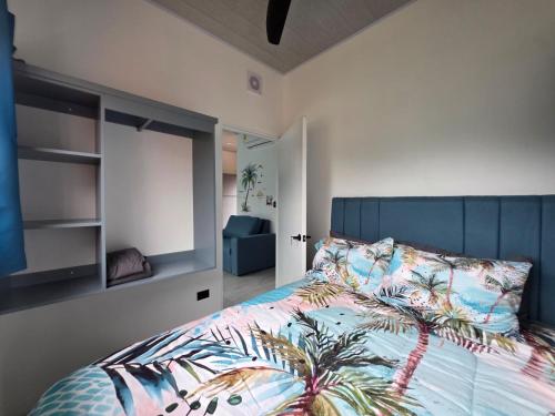 a bedroom with a bed with a blue headboard at The Palm at Life's a Beach in Uvita