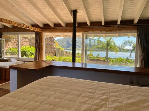 a bedroom with a bed and a view of the water at Hospedaria Ponta da Piteira in Imbituba