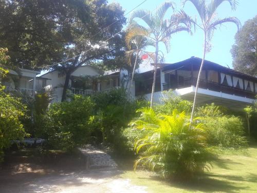 a house with palm trees in front of it at Villa Mar Sosua in Sosúa
