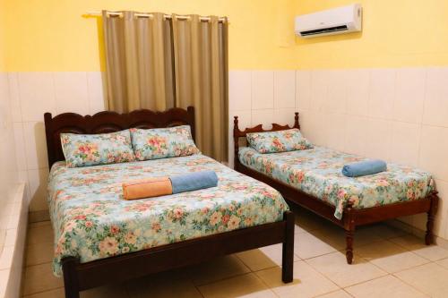 a bedroom with two beds with pillows on them at Ybirá - Casa Inteira no Centro de Alter do Chão in Alter do Chao