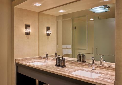 a bathroom with two sinks and a large mirror at MGM Grand Detroit in Detroit