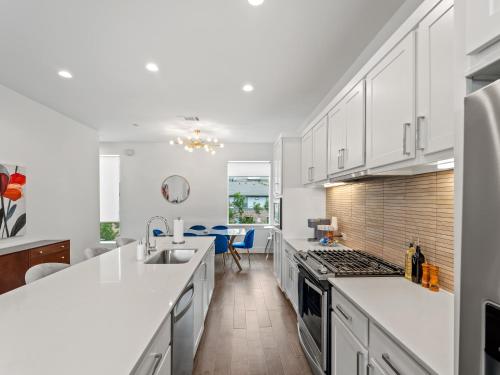 a kitchen with white cabinets and a counter top at Modern Dallas Townhome with Private Rooftop, City View, Private Parking & Grill in Dallas
