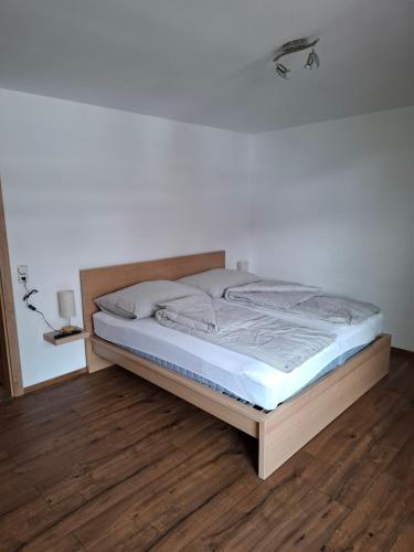 a large bed in a room with a wooden floor at Haus Nadegger in Werfen