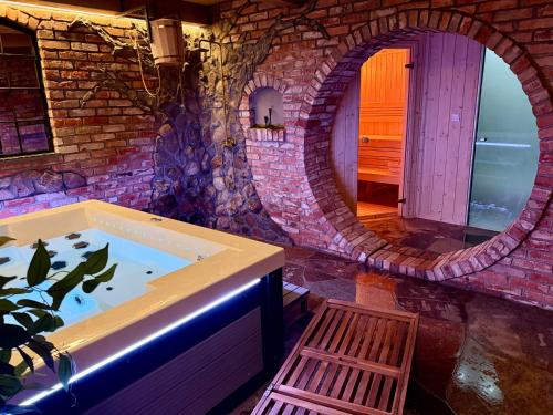 a large bathroom with a tub with a mirror at Siedlisko Miluki - Apartamenty nad Jeziorem z Jacuzzi & Sauną in Ełk