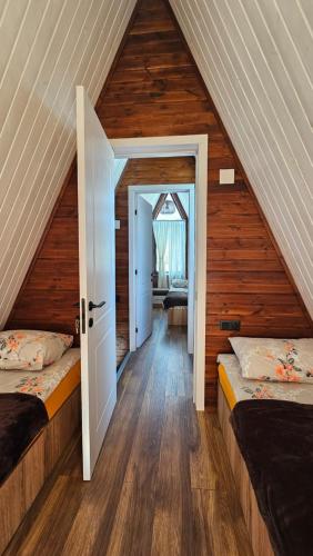a attic room with two beds and a hallway at B&B Cottages Mestia-Sauna & Hot Tub in Mestia
