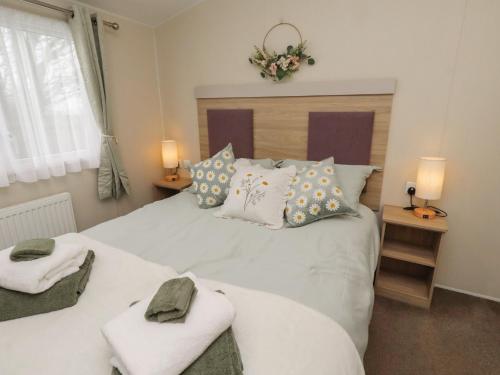 a bedroom with a large white bed with towels on it at Homeslea 33 Millennium Gardens in Morpeth