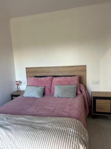 a large bed with purple sheets and two pillows at Apartamentos luz de Doñana 1 in Moguer