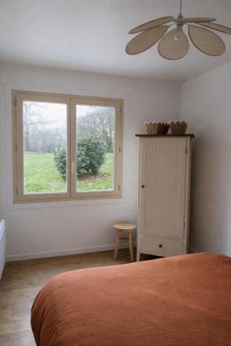 a bedroom with a bed and a window at Maisonnette à la campagne in La Couyère