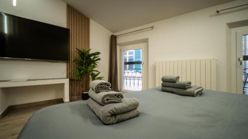 a room with a bed with towels on it at ESTENSIA Room & Suite in Ferrara