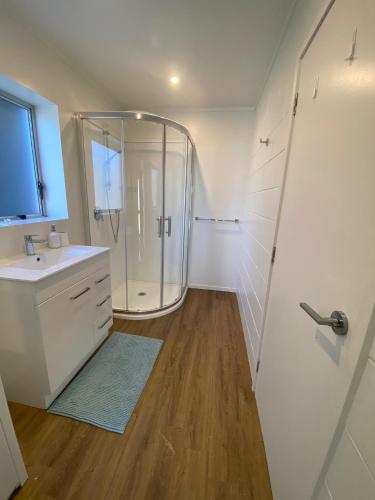a bathroom with a shower and a sink at The Rock House, Patons Rock in Rangihaeata