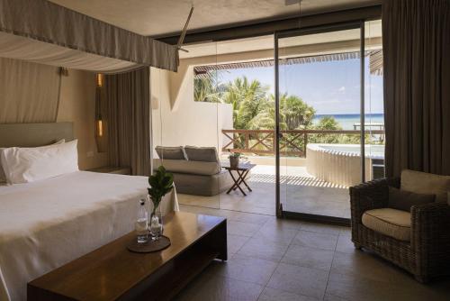 a hotel room with a bed and a view of the ocean at Azure Horizon Suite in Balcheil