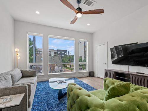 a living room with a couch and a tv at Modern Dallas Townhome with Private Rooftop, City View, Private Parking & Grill in Dallas