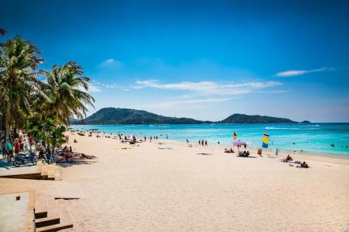 a group of people on a beach with the ocean at Global Hills Hotel in Patong Beach