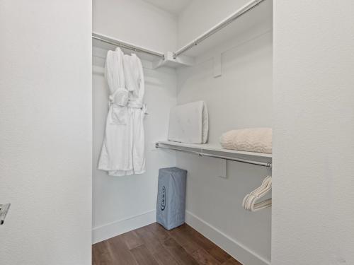 a walk in closet with white walls and wooden floors at Modern Dallas Townhome with Private Rooftop, City View, Private Parking & Grill in Dallas