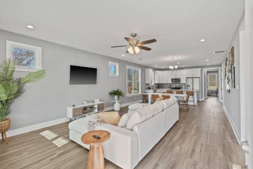 a living room with a white couch and a table at Gated Parking + Fire Pit | Near Zoo + Rhodes in Memphis