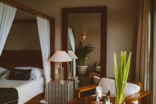 a bedroom with a bed and a table and a mirror at Coral Breeze Retreat in Balcheil