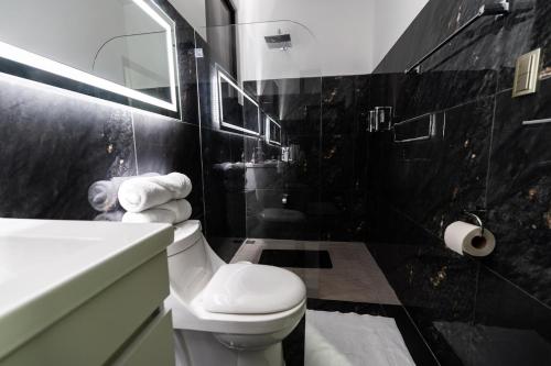 a black and white bathroom with a toilet and a sink at La Danta Lodge - Rio Celeste in Bijagua
