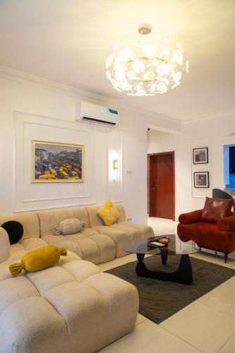 a living room with two couches and a chandelier at Ashtead Haven in Ikate