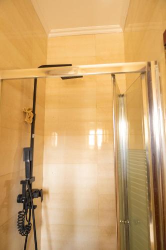 a shower in a room with a camera on the wall at Ashtead Haven in Ikate