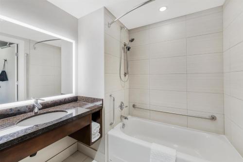 a bathroom with a tub and a sink and a toilet at Best Western Plus Revelstoke in Revelstoke