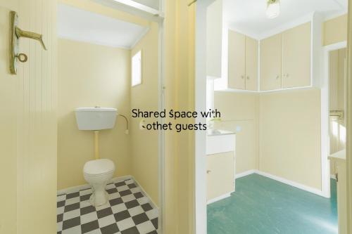 a bathroom with a toilet and a checkered floor at Boxed Bliss on Fox in Hamilton