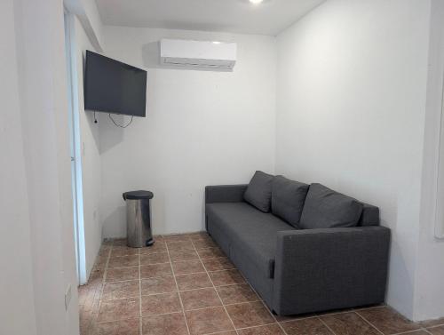 un soggiorno con divano e TV a schermo piatto di Villa Mango a Fajardo