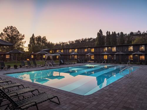 a large swimming pool with chairs in front of a building at High Country Motor Lodge - Near NAU and Downtown in Flagstaff
