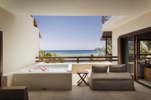 a living room with a tub with a view of the ocean at Sunset Crown Suite in Balcheil