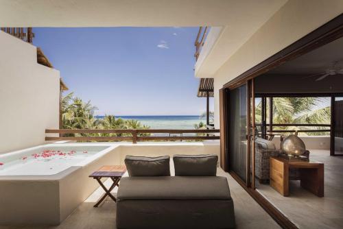 a bathtub in a room with a view of the ocean at Sunset Crown Suite in Balcheil