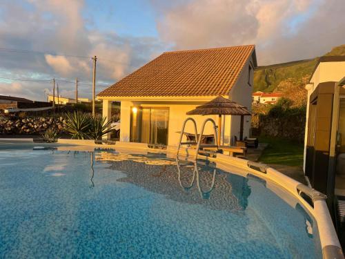 a house with a swimming pool in front of a house at Spot Milasmar in Faja Grande