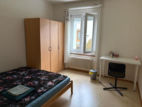 a bedroom with a bed and a desk and a window at Italian Guesthouse in Baden