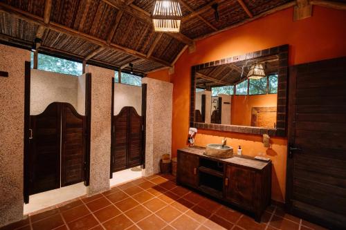 a bathroom with a sink and a large mirror at Whale Island Resort in Dam Mon
