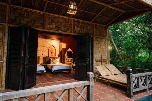 a porch of a house with a bed and a couch at Whale Island Resort in Dam Mon