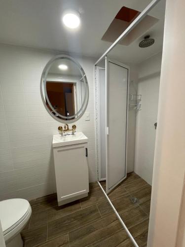 a bathroom with a white toilet and a mirror at Apartamento 25 Centrico Chapala in Chapala