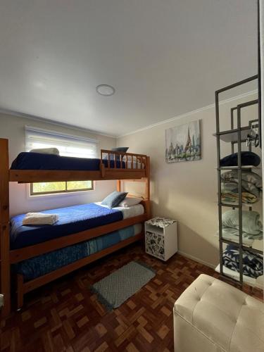 a bedroom with two bunk beds and a couch at Mels House Batuco in El Cerrillo