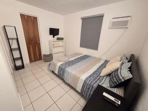 a small bedroom with a bed and a window at Beach Hub 7 Mins to Airport in Carolina