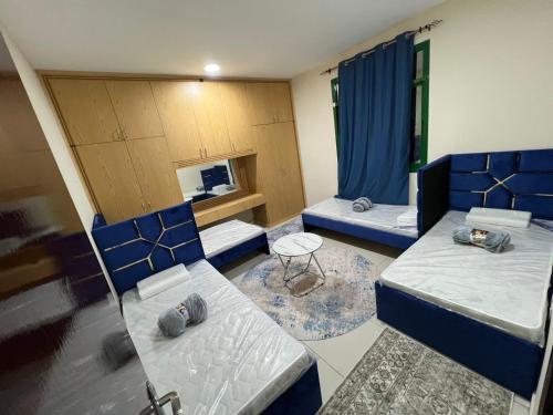 a room with two beds and a table at ALEX Hostel - Bed in a shared room - C504 in Sharjah