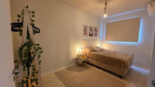 a small bedroom with a bed and a window at Praia e Cambirela in Palhoça