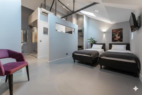 a bedroom with two beds and a chair at Stylish Suite near Gouden Ham WiFi AC in Oss