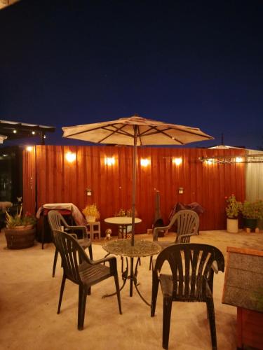 a patio with a table and chairs and an umbrella at Santa Maria Corio 2BR Corporate Stay & Ferry Base in Corio