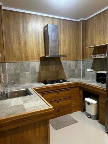 a kitchen with wooden cabinets and a sink and a stove at Kamala cozy home in Kamala Beach