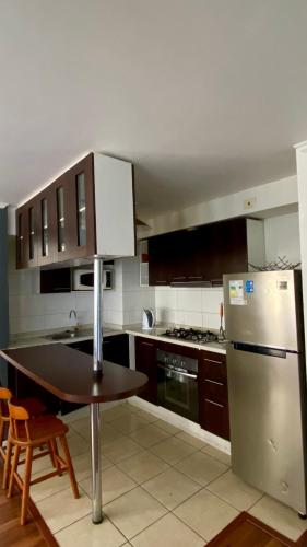 a kitchen with a table and a stainless steel refrigerator at Borde Costero in Valparaíso
