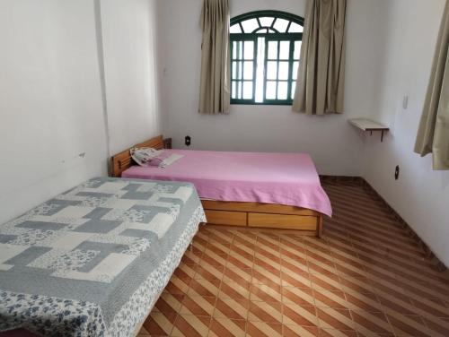 a bedroom with two beds and a window at Casa Branca in Vila Velha