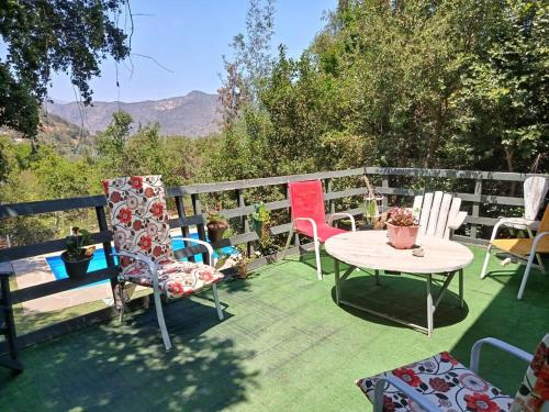 a patio with chairs and a table and a fence at Casa Olmué in Olmué