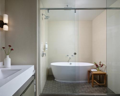 a white bathroom with a tub and a sink at Kimpton Hotel Palomar Phoenix Cityscape by IHG in Phoenix