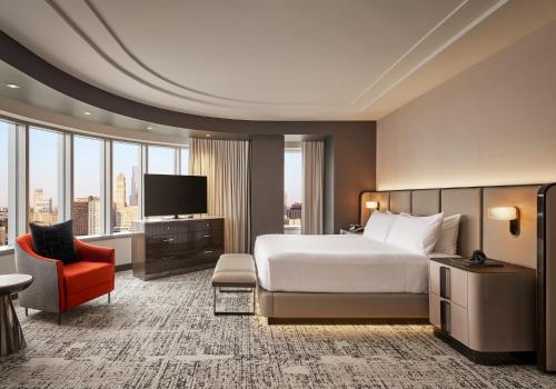 a hotel room with a bed and a red chair at MGM Grand Detroit in Detroit