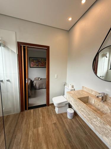 a bathroom with a toilet and a sink and a mirror at Pousada Cobogó - MotoWeek, ANP in Brasília